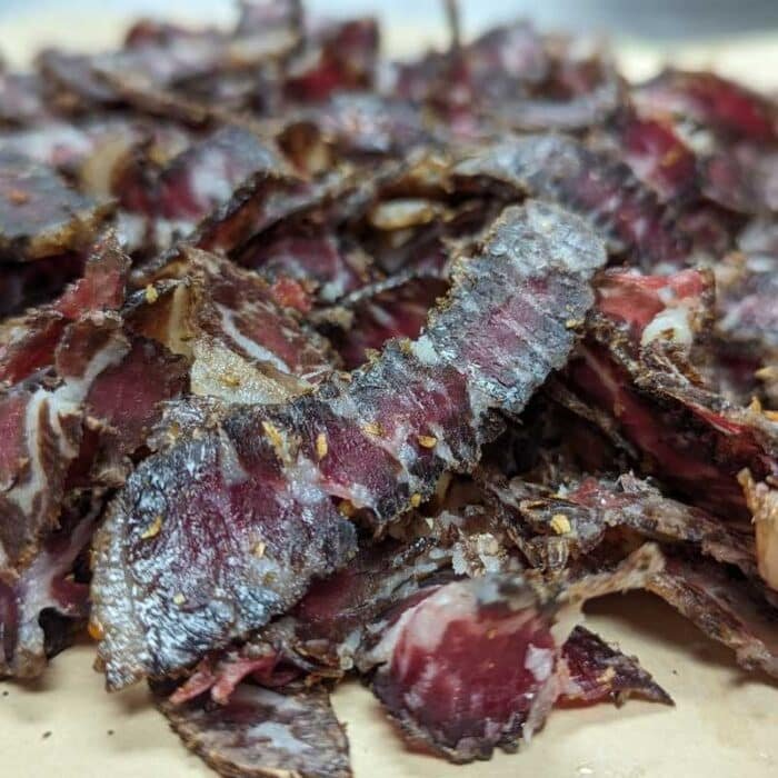 A pile of sliced biltong on a table showing the marbling