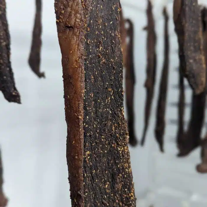 A close up of biltong hanging from a rack