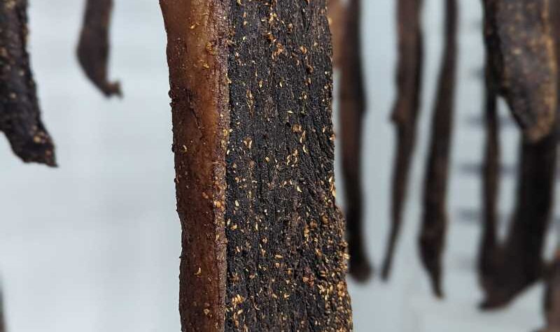 A close up of biltong hanging from a rack