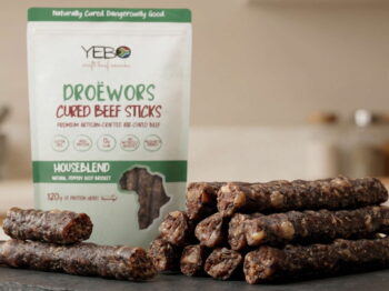 Yebo Droëwors cured beef sticks on slate board with packaging in kitchen setting.