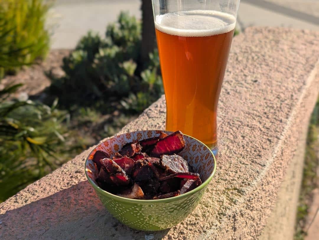 Bowl of biltong beside beer