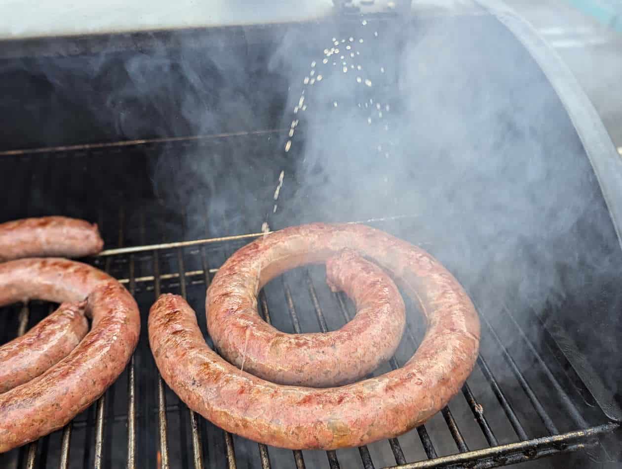 Grilling boerewors with some juicy fat creating smoke