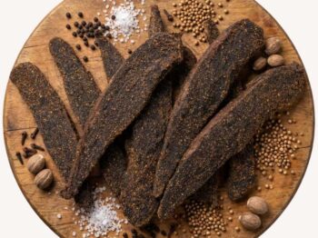Biltong Slabs on a round wooden platter with spices.