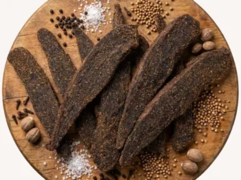 Biltong Slabs on a round wooden platter with spices.