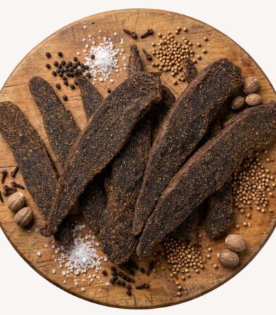 Biltong Slabs on a round wooden platter with spices.