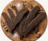 Biltong Slabs on a round wooden platter with spices.