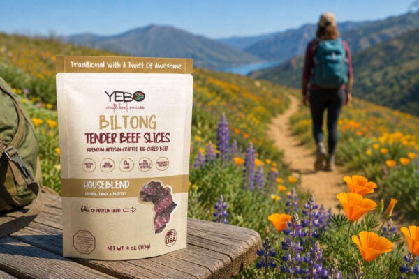 Portable biltong snacks on a hiking trail surrounded by wildflowers and mountain scenery.