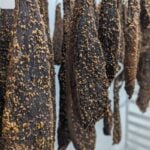 Spiced biltong beef strips hanging to dry in a traditional South African curing process.