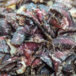 Close-up of sliced dried biltong beef with rich texture and spices.