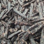 Close-up of dried beef jerky sticks with rich brown color and textured surface.